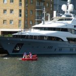 Large yaught in London Docklands and two small rowing boats.